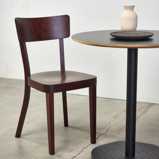 Dunkelbrauner Holzstuhl im klassischen Beizenstil neben rundem Bistrotisch mit Vase schlichtes Design für Restaurant oder Esszimmer